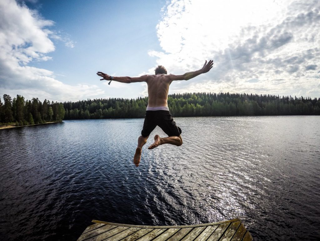 jongen springt in het water met zwemshort aan met een boxershort