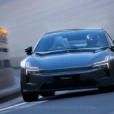 Vooraanzicht van de Polestar 5 in Gran Turismo 7 met coureur aan het stuur, terwijl de elektrische GT door een bocht accelereert met zijn futuristische koplampen in beeld.