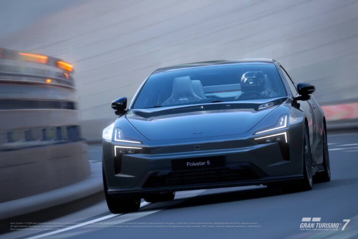 Vooraanzicht van de Polestar 5 in Gran Turismo 7 met coureur aan het stuur, terwijl de elektrische GT door een bocht accelereert met zijn futuristische koplampen in beeld.