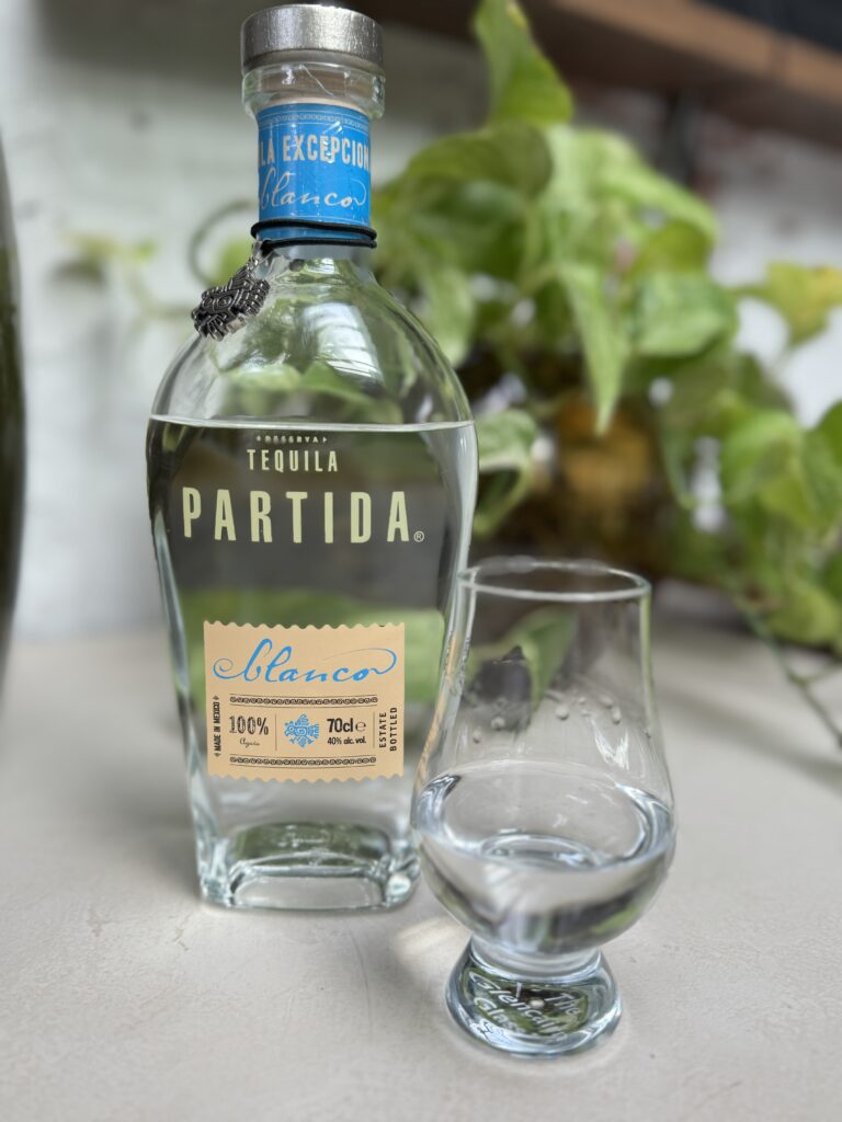 Fles van de partida blanco met een glas ernaast ingeschonken klaar om te proeven
